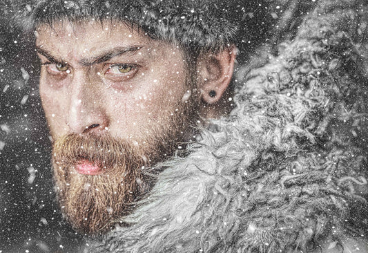 man with beard covered in snow looking into the camera