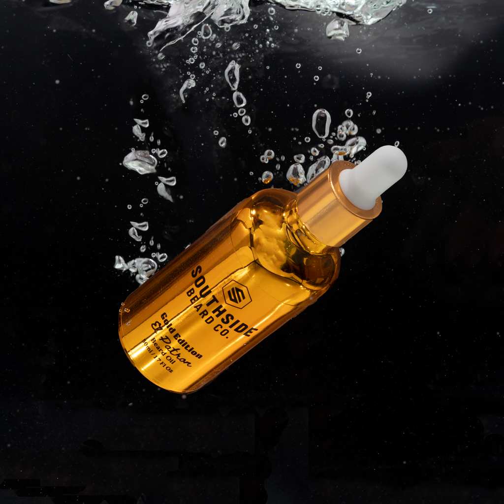 50ml gold dropper bottle from southside beard co floating in water with a black background