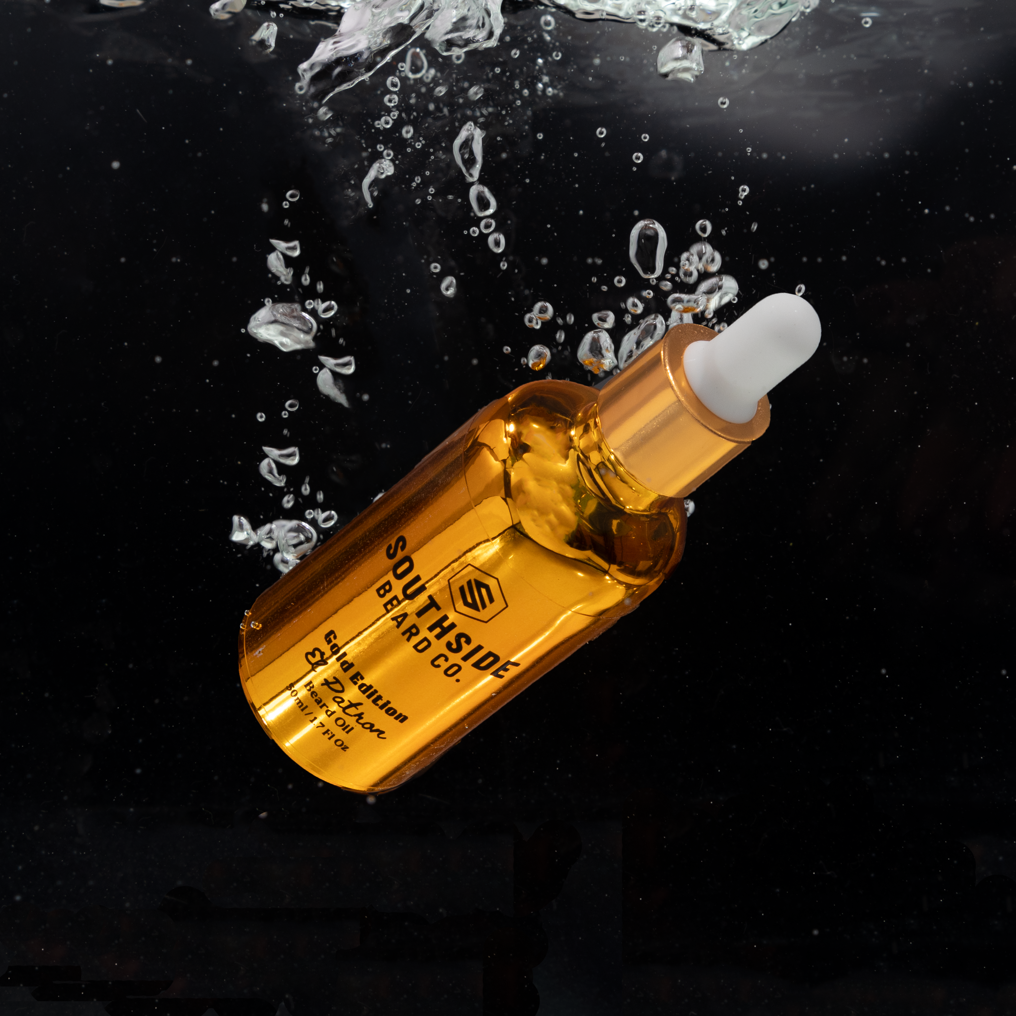 50ml gold dropper bottle from southside beard co floating in water with a black background