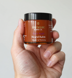 Hand holding a Southside Beard Co. Dark Night Beard Balm jar against a neutral background