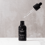 Black edition beard oil from Southside beard co with 30ml glass dropper and pipette floating in the background