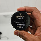 Hand holding a Southside Beard Co. desert island beard balm container.