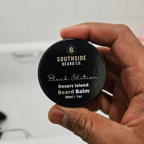 Hand holding a Southside Beard Co. desert island beard balm container.